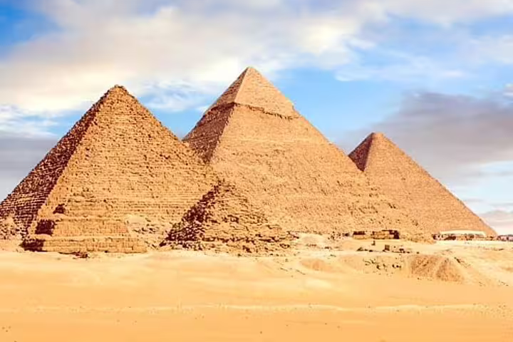 Panoramic view of the three Pyramids of Giza under blue sky on Cairo day tour by plane from Sharm El Sheikh