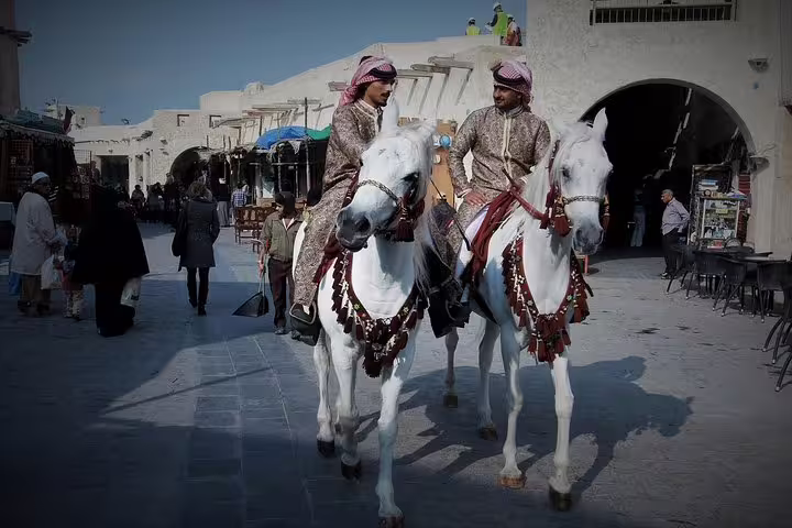 Traditional Qatari horsemen in Souq Waqif, Doha, offering a glimpse into the rich cultural heritage.