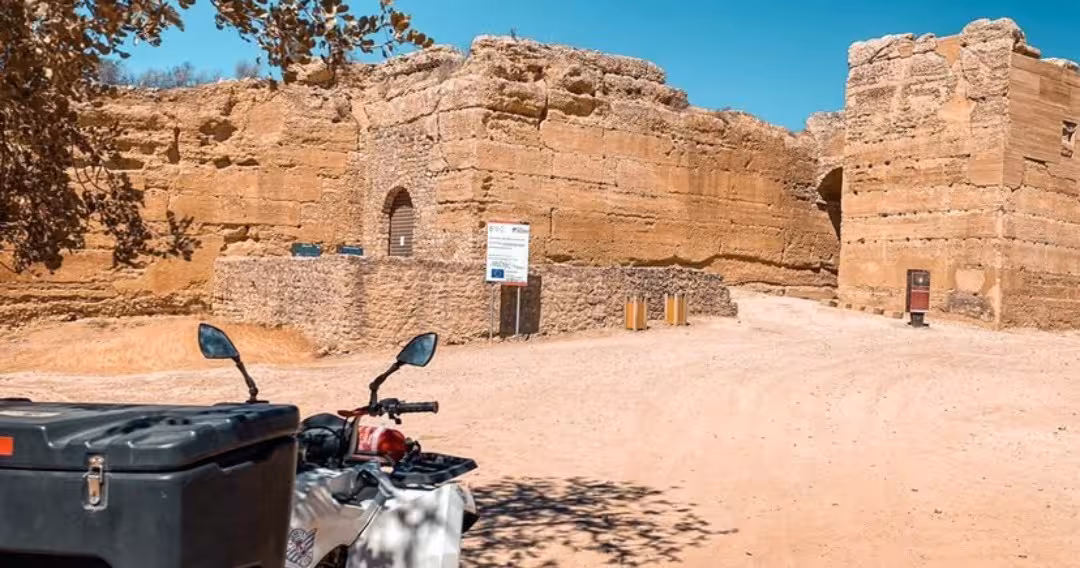 Quad bike parked beside ancient stone ruins on a sunny full day off road quad tour in rural Spain