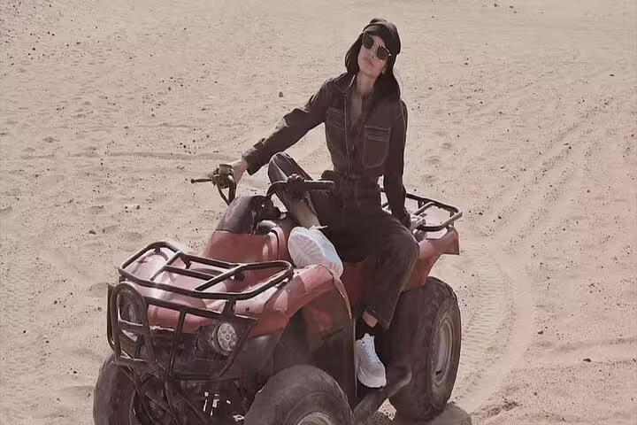 Woman riding a quad bike across Giza Desert sands, thrilling 1-hour ATV safari near the pyramids at sunrise