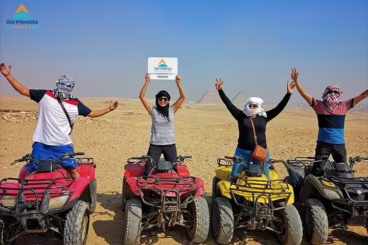 Group on quad bikes in Giza Desert with pyramids backdrop, perfect 1-hour sunrise or sunset ATV safari