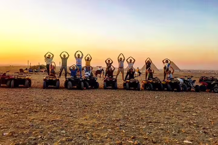 Group quad bike safari around the Pyramids of Giza at golden hour, travelers posing on ATVs in desert