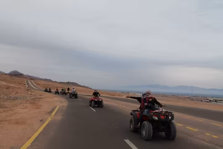 Quad bike convoy on desert road near Sharm El Sheikh, guided ATV safari adventure with stargazing and dinner show