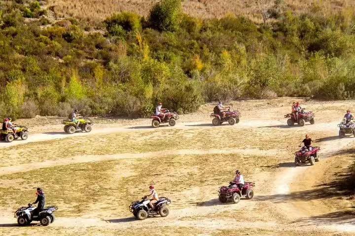 Adventurous group rides quad bikes across scenic trails near Kusadasi Port, exploring beautiful landscapes and nature.