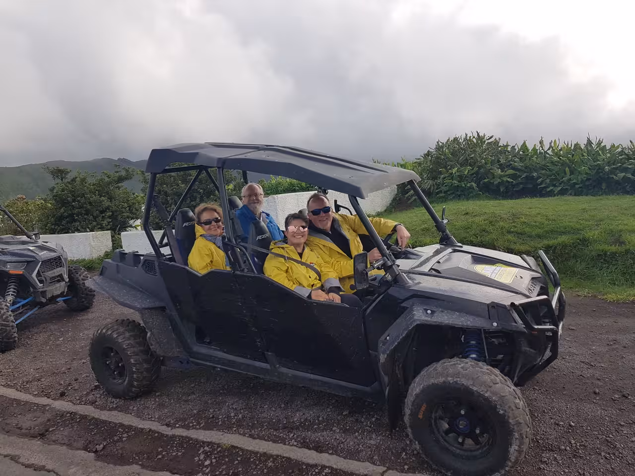 Group of friends in a side‑by‑side buggy enjoying a guided off‑road Sete Cidades crater tour with scenic Azores views
