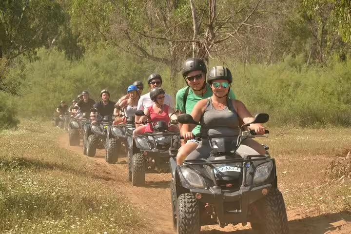 Group of tourists enjoying a quad riding adventure through lush trails near Kusadasi Port.