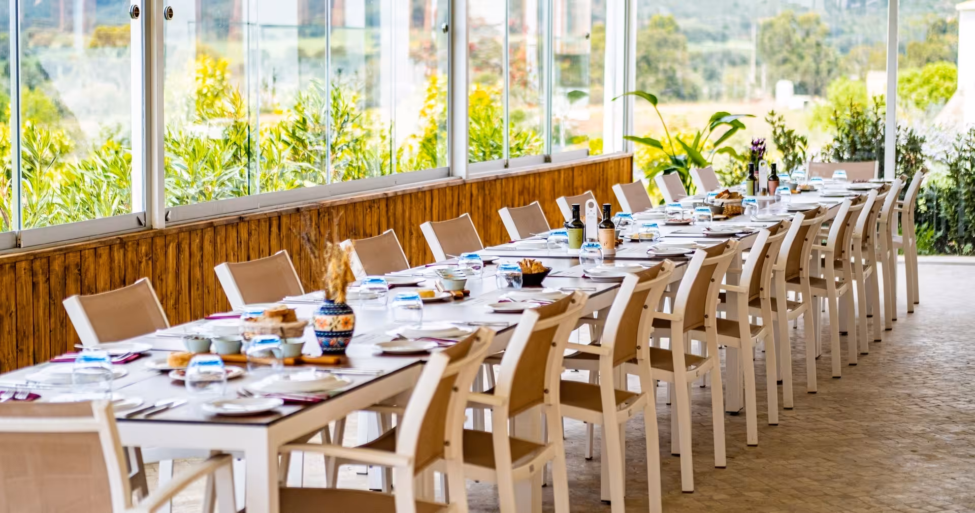 Long sunlit terrace table set for a traditional countryside lunch included in the Full Day Quad Tour experience.