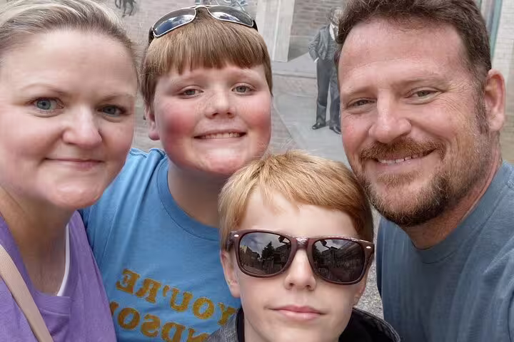 Family selfie in Old Quebec near historic mural stop on Quebec City scavenger hunt and city highlights tour