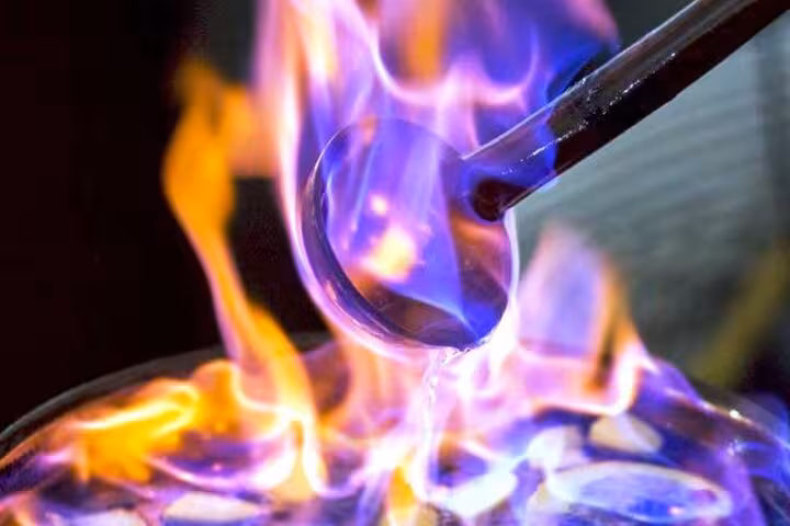 Close-up of blue and orange flames during a queimada preparation at Santiago de Compostela event.