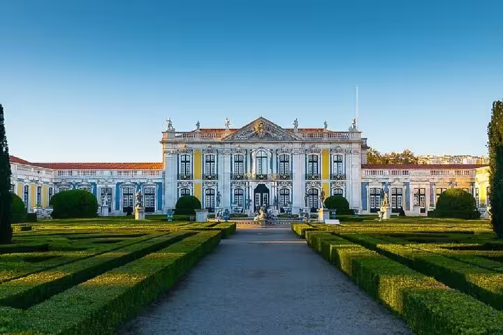 Majestic view of Queluz Palace with manicured gardens, featured in the Lisboa private full-day tour to Mafra and Ericeira.