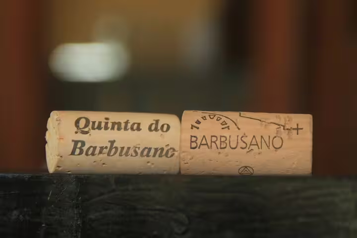 Close-up of two wine corks from Quinta do Barbusano, highlighting the vineyard's branding for a jeep wine tour adventure.