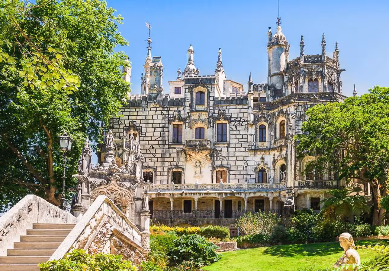 Explore the stunning architecture of Quinta da Regaleira in Sintra, surrounded by lush greenery and intricate stonework.
