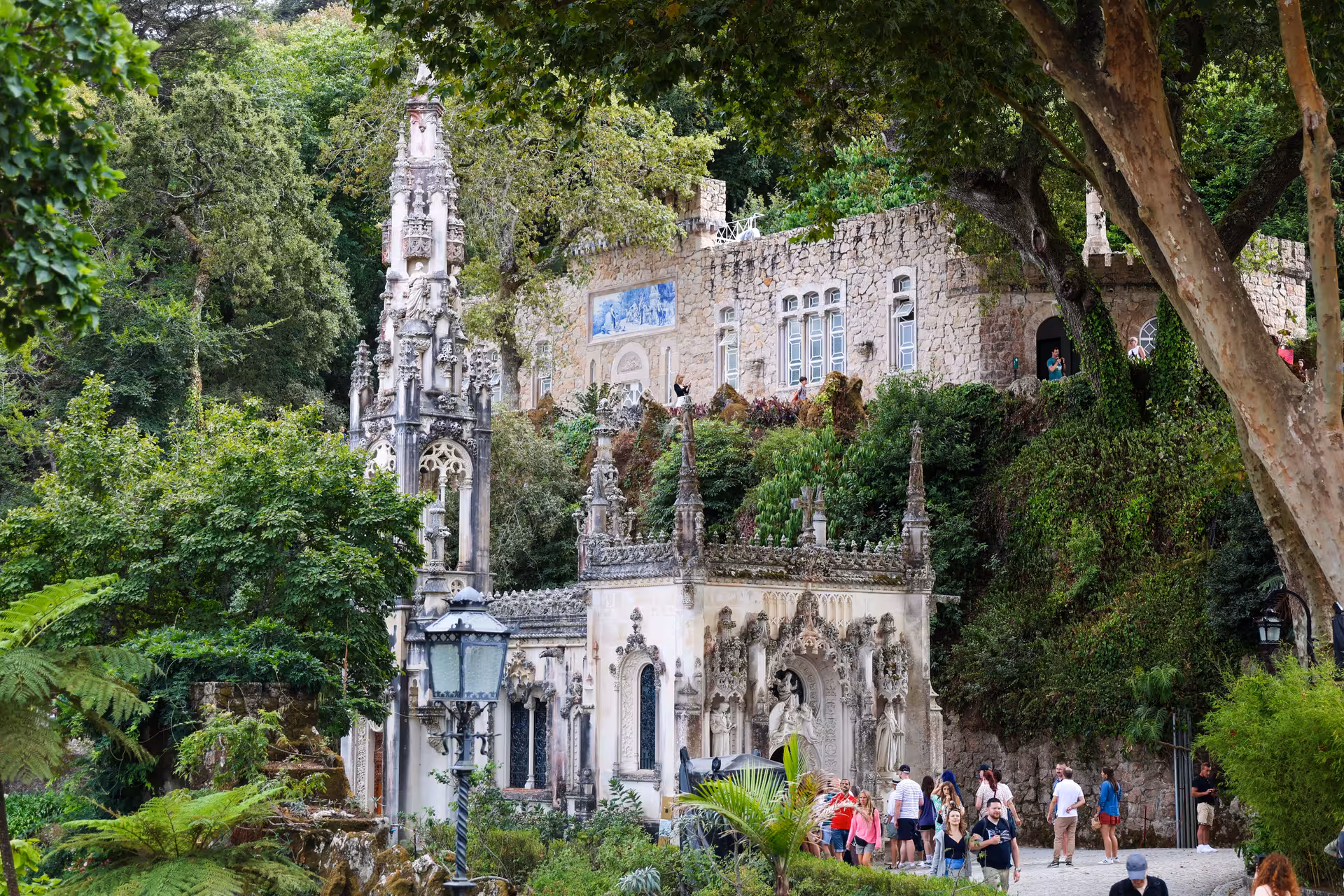 Quinta da Regaleira's ornate Gothic structure surrounded by lush greenery, a highlight of the Sintra small group tour.