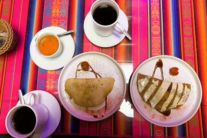 Traditional Ecuadorian desserts and coffee on vibrant textiles, featured in Quito's hidden gems food and cacao tasting tour.
