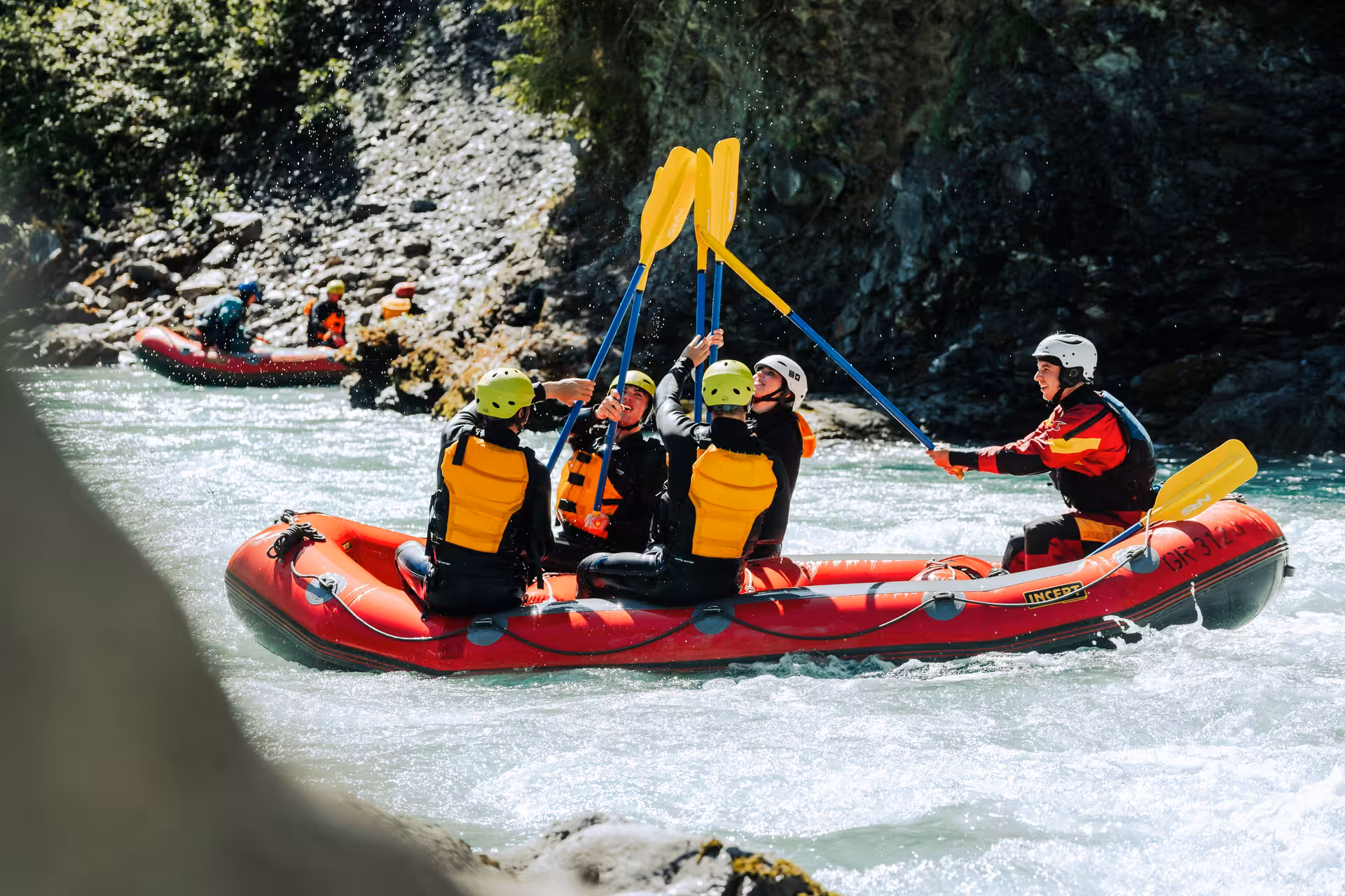 Team celebrates successful rafting on Interlaken's scenic whitewater, epitomizing outdoor fun.