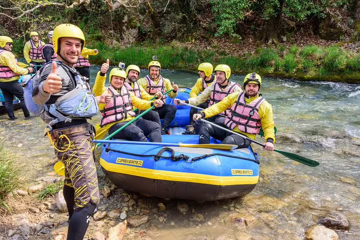 Rafting team in helmets and life vests launching raft on Lousios–Alfeios rivers, Peloponnese Greece