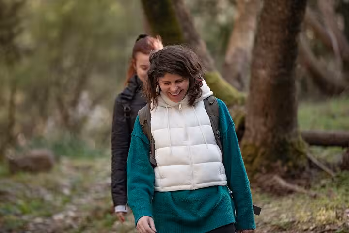 Smiling hikers walk through Randi Forest on Ikaria island, enjoying a guided nature trail on the Seychelles beach tour