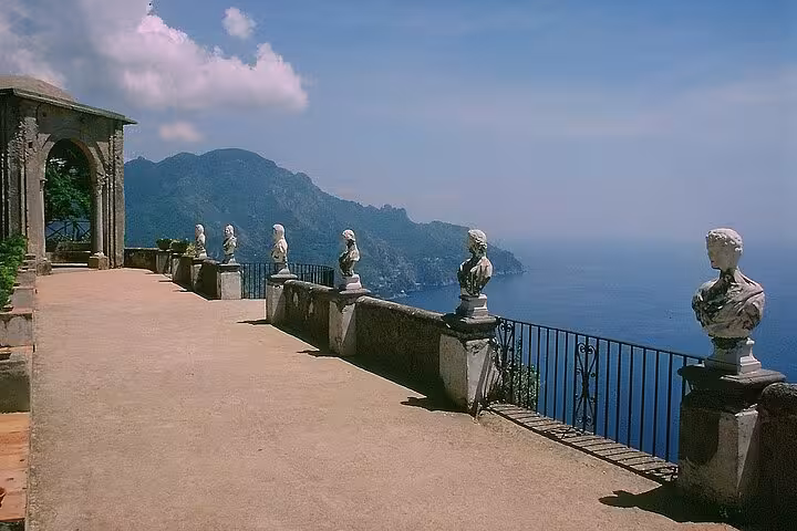 Panoramic view of the Amalfi Coast from Ravello's terrace, featuring classical statues and breathtaking seascape.