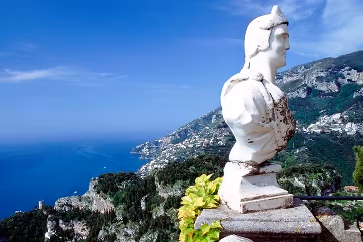 Stunning coastal view from Ravello with ancient statue, perfect for travelers on Positano and Amalfi tour.