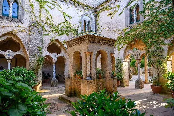 Serene courtyard in Ravello adorned with lush greenery and historic arches, ideal for a tranquil private tour experience.