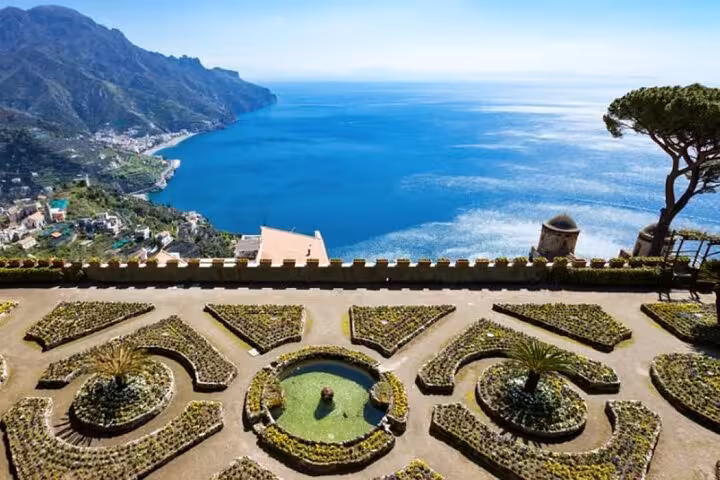 Stunning view of Ravello's gardens overlooking the Amalfi Coast, showcasing vibrant foliage and the sparkling Mediterranean Sea.
