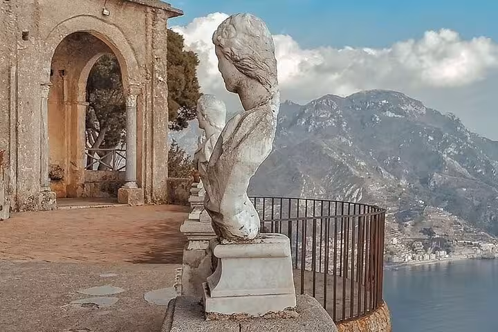 Stone busts overlooking the Amalfi Coast from a historic terrace in Ravello during a half-day tour.