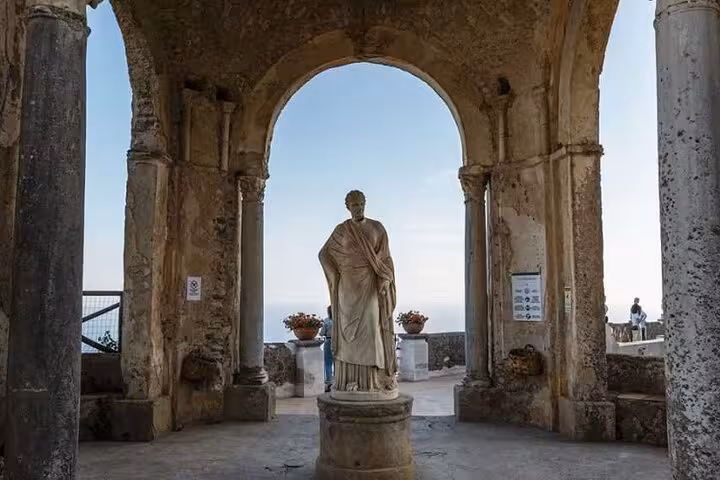 Statue in a historic archway overlooking the sea in Ravello, featured on the Positano, Amalfi, and Ravello tour from Naples.