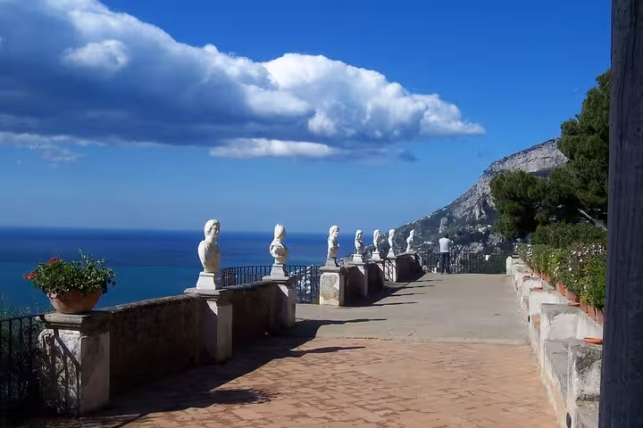 Historic statues overlooking the sea under a blue sky in Ravello, ideal for showcasing Amalfi Coast attractions.