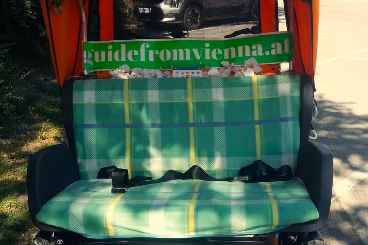 Comfortable plaid bench seat inside RAXI e-rickshaw for a big private Vienna city tour ride
