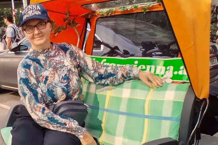 Traveler seated in e-rickshaw on big private Vienna tour, comfortable electric ride for city highlights