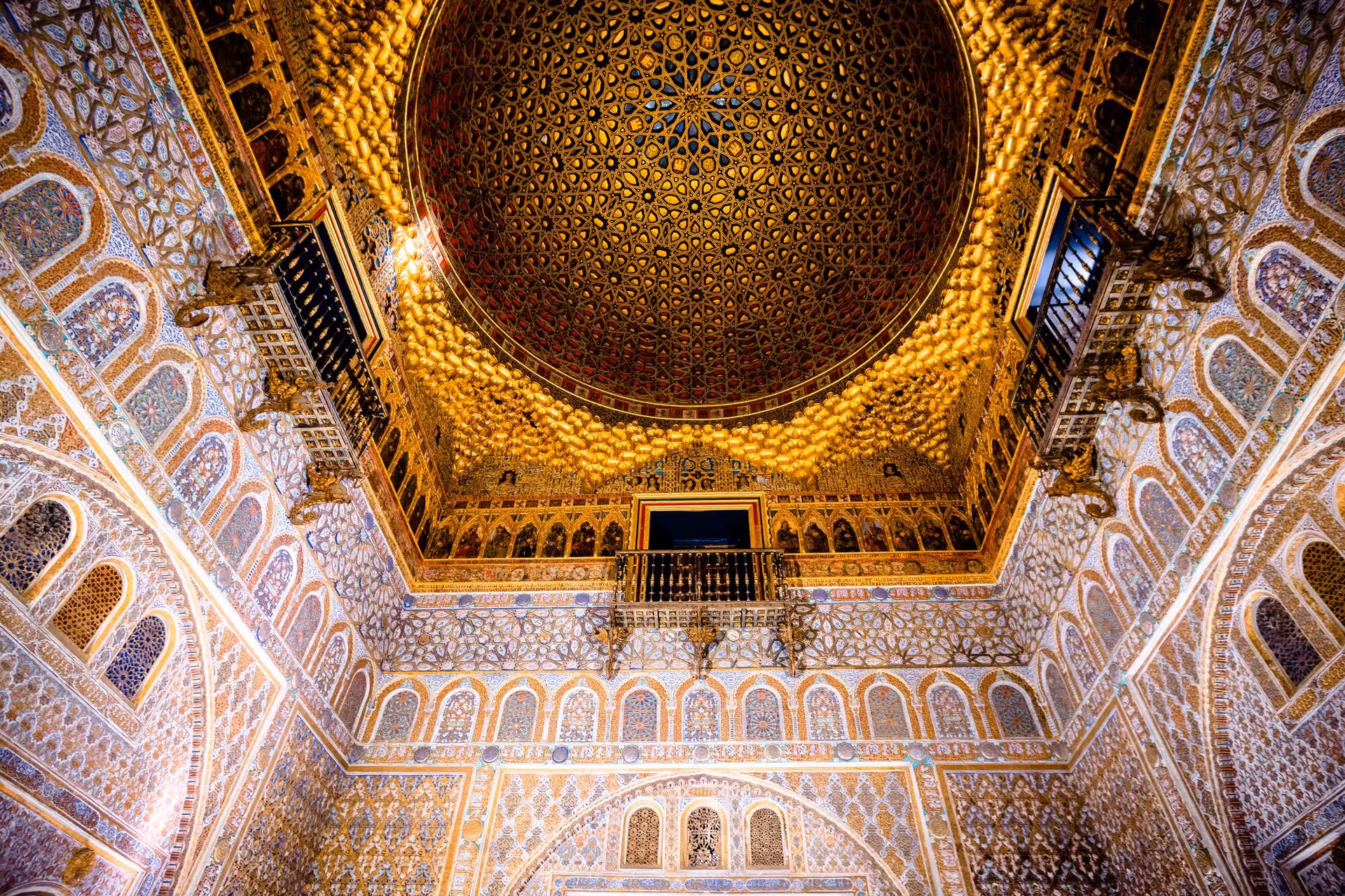 Stunning gold-domed ceiling with intricate architectural details in the Real Alcázar of Seville.