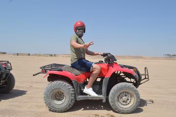Rider on red ATV quad bike in Sharm El Sheikh desert, ideal for sunrise or sunset quad safari tour