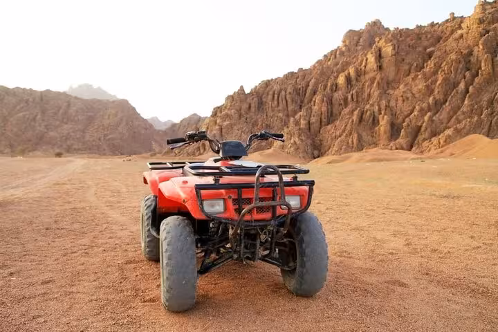 Red ATV quad parked in rocky Sinai Desert valley near Echo Mountain, Sharm El Sheikh quad safari experience