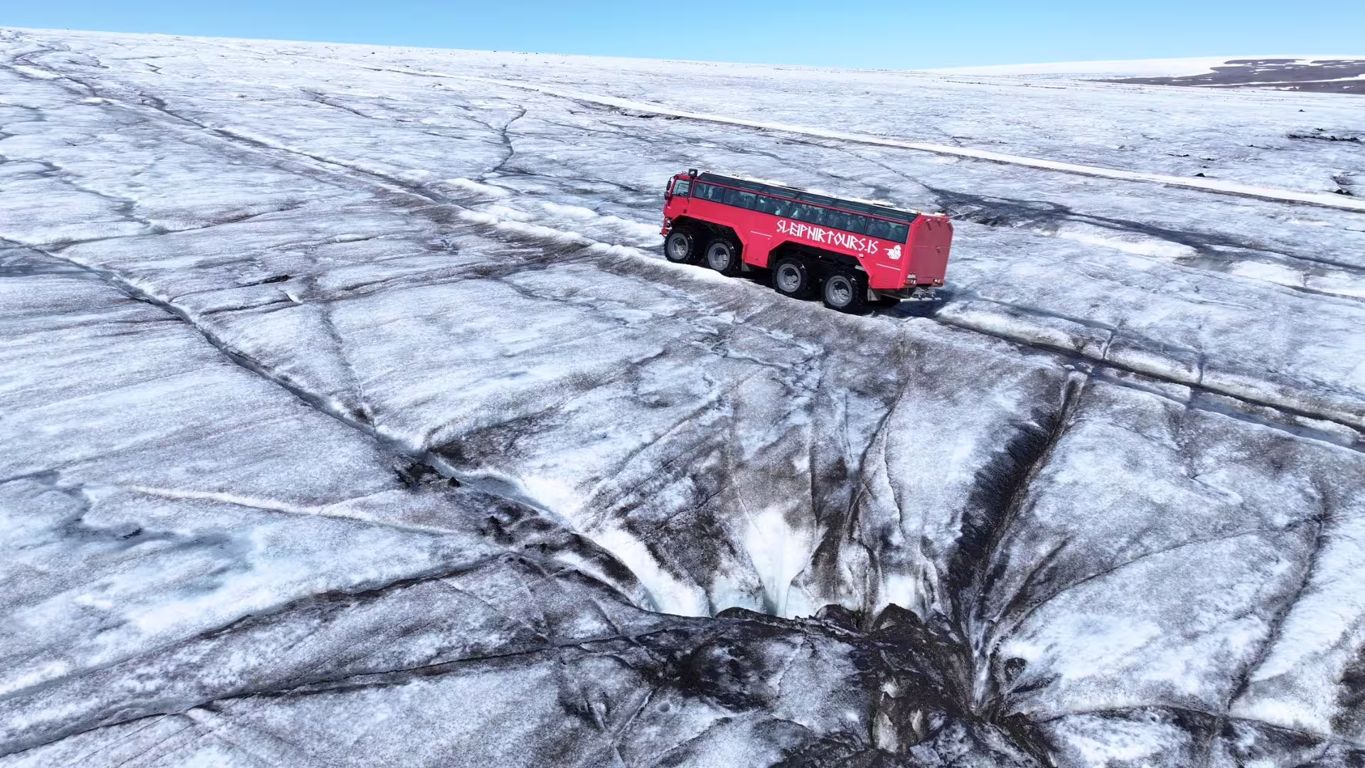 Red glacier truck crossing Langjökull ice on Summer Solstice tour from Gullfoss, Iceland glacier adventure