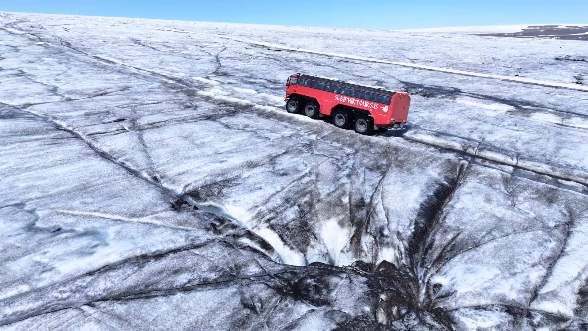 Red monster truck on Langjökull glacier near crevasses, thrilling Gullfoss departure ice tour