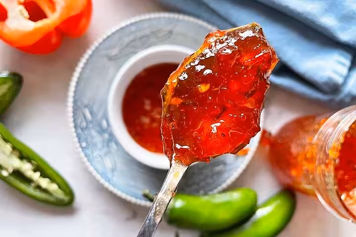 Spoonful of vibrant red pepper jelly, a spicy treat featured in Rio's Cookin' Good culinary fiesta and market tour.