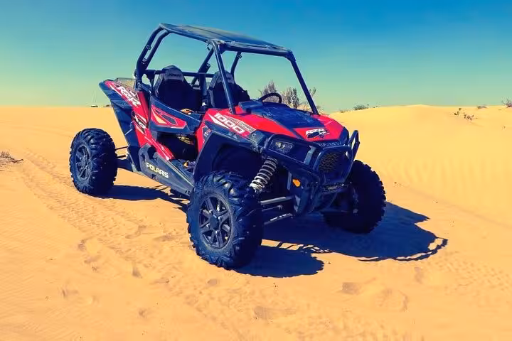 Red Polaris off-road buggy on golden dunes in Sharm El Sheikh, Egypt, ready for desert safari adventure