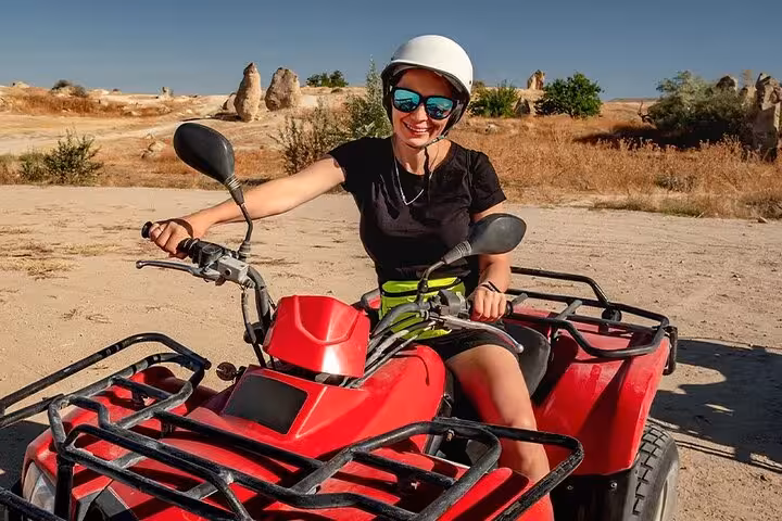 Traveler riding a red quad bike in the desert near Sharm El Sheikh, part of water sports and safari tour