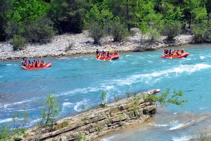 Red rafts floating on turquoise river in a forest canyon, great threesome rafting buggy zipline adventure day