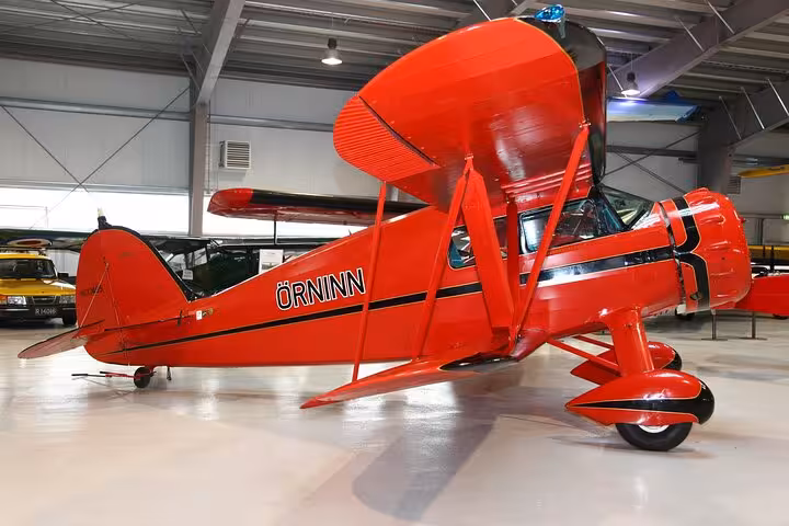 Explore a stunning red vintage biplane on display at an Akureyri museum, ideal for aviation enthusiasts in Iceland.