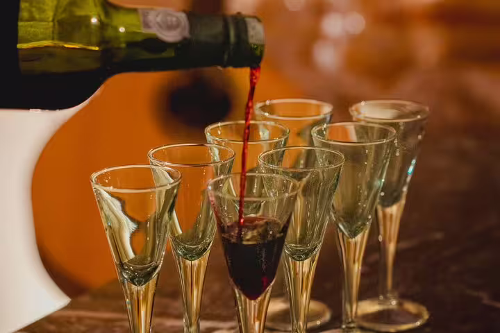 Pouring rich red wine into elegant glasses, setting the stage for an authentic Lisbon Fado show experience.
