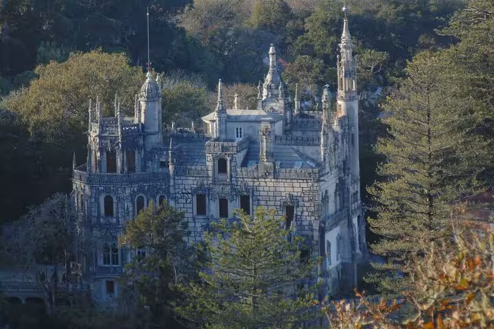 Aerial view of the enchanting Regaleira Palace surrounded by lush greenery in Sintra, ideal for cultural exploration tours.