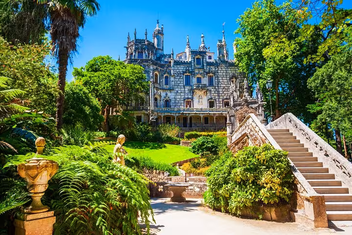Explore the enchanting Regaleira Palace gardens in Sintra, surrounded by lush greenery and stunning architecture.