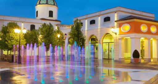 Colorful evening fountains at La Reggia Designer Outlet near Caserta, ideal shopping stop on Reggia di Caserta guided tour