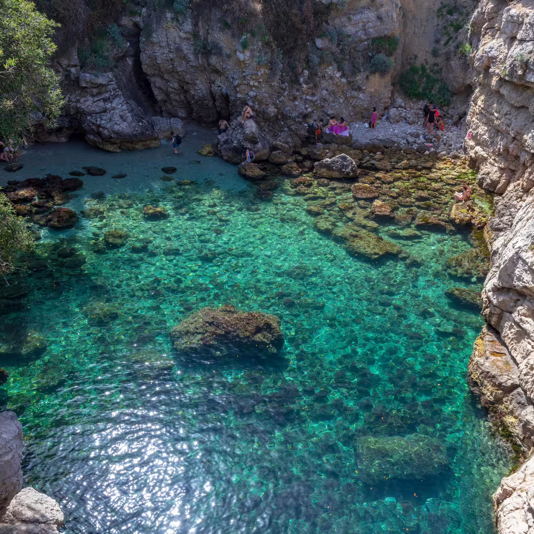 Hidden natural pool at Bagni della Regina Giovanna with crystal-clear turquoise water and rocky cliffs near Sorrento