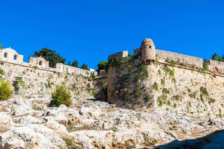 Explore the historic walls of Rethymno, showcasing ancient architecture under a vibrant blue sky.