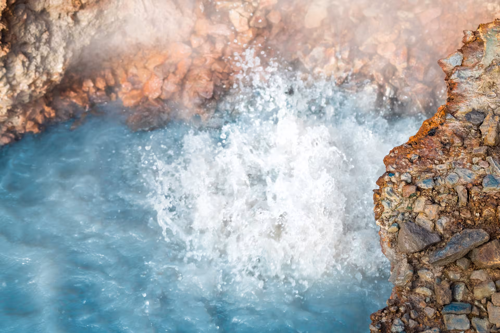 Bubbling blue hot spring pool with steam and mineral rocks on Reykjadalur Grændalur private hike tour