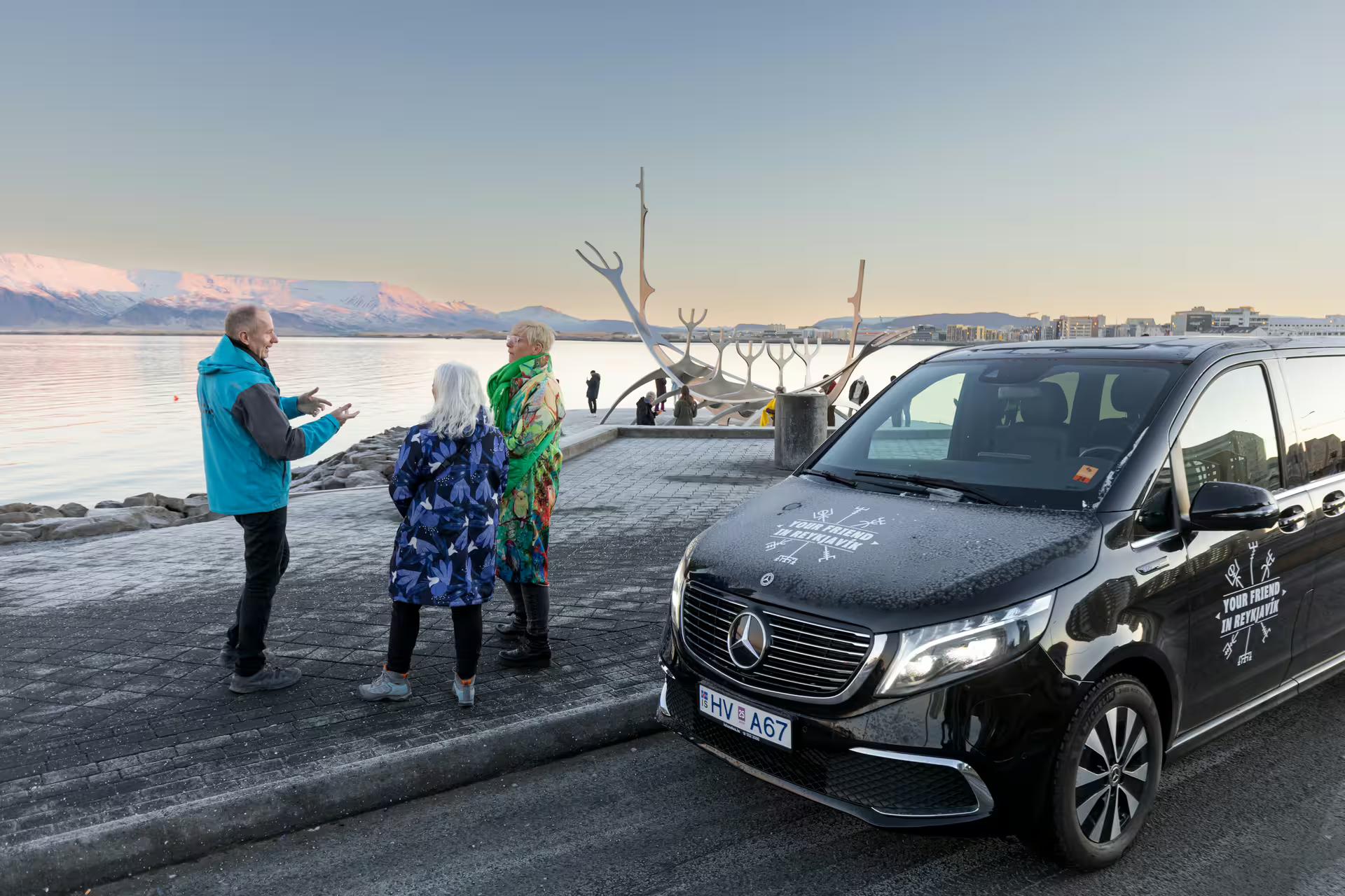 A group of travellers next to a tour vehicle from Your Friend in Reykjavik 