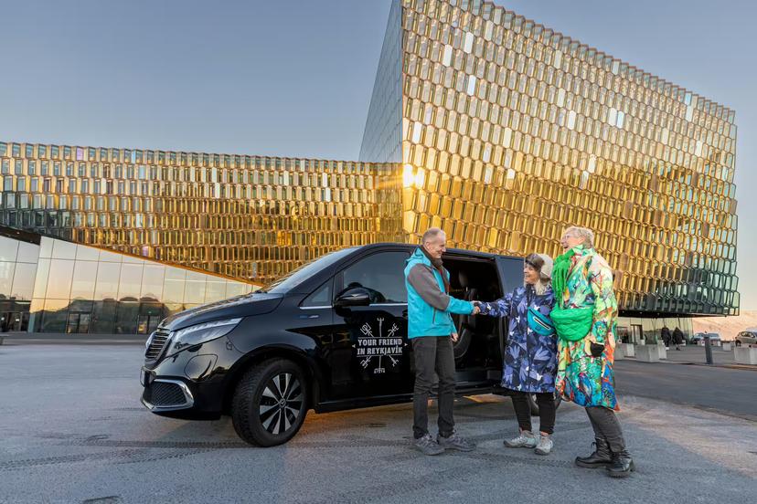 A group of travellers greeting a Guide from Your Friend in Reykjavik in front of the Harpa Concert Hall in Reykjavik
