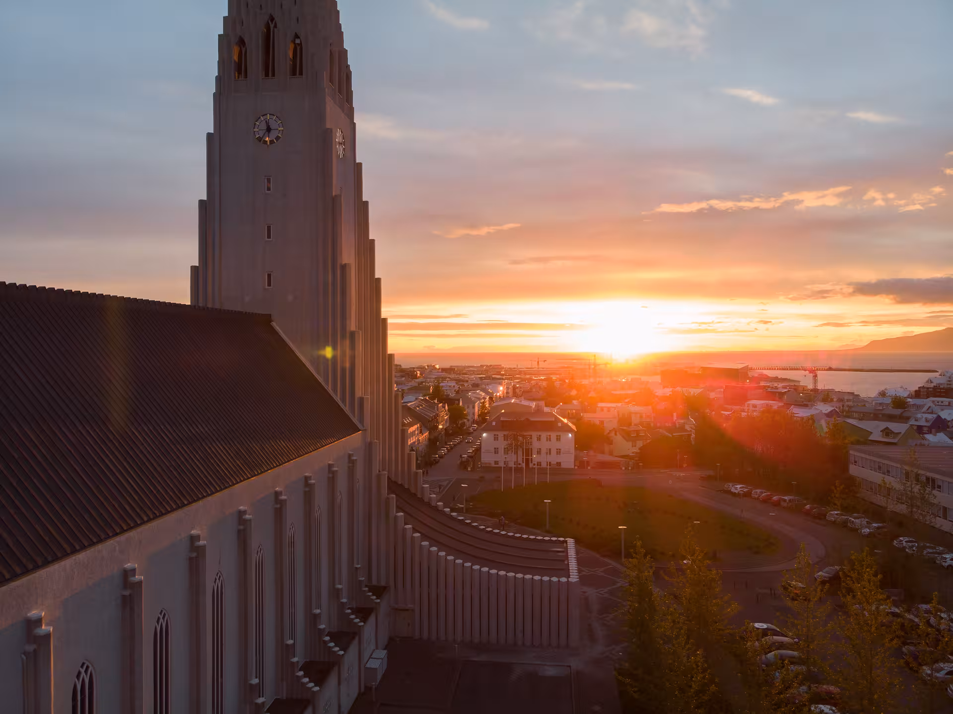 Sunset view over Reykjavik with iconic church spire, ideal for private city tour photography.